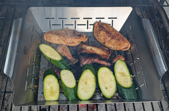 Zuchinni, king oyster mushrooms and Quorn chik'n cutlets grilling in a veggie basket on the barbecue